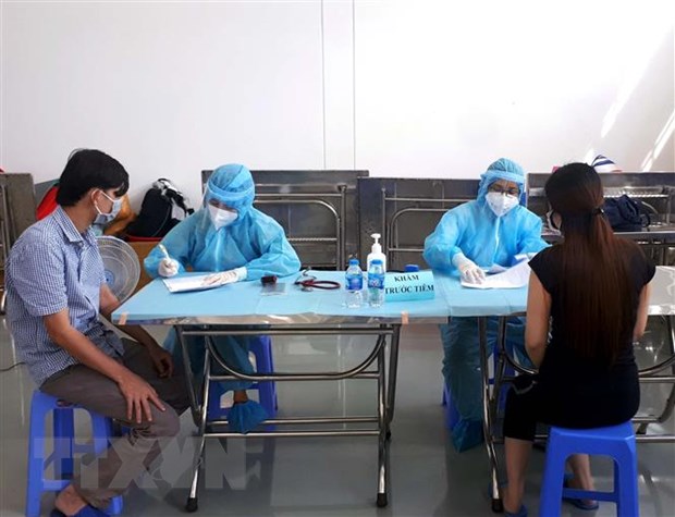 Các công nhân đang làm việc theo phương án '3 tại chỗ' tại Khu chế xuất Tân Thuận, quận 7, Thành phố Hồ Chí Minh kiểm tra y tế trước khi tiêm mũi vaccine thứ 2